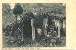 Nouvelle Calédonie — Fétiches utilisés comme masques de guerre. Édition de la Commission Suisse de la Mission de Paris. No 51 Cliché Ph. Delo-- ? Imp. Rotogravure, Plainpalais-Genève. 9,2 x 14,3 cm. Il s’agit probablement de Philippe Delord, pasteur des Missions Evangéliques de Paris. On lui doit, outre ses photos : Mon voyage d’enquête en Nouvelle-Calédonie, août-septembre 1899, Paris, 1901. Celui de droite est un costume de deuilleur complet composé d’un masque en bois, d’un manteau en plumes de notou et d’une coiffure en cheveux humains. 