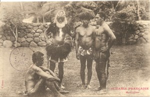 « Océanie Française. Marquisiens. F. Homes. ». Cachet postal du 17 septembre 1908. 8,8 x 13,8 cm. On retrouve le personnage à la barbe blanche portant un disque frontal uhikana sur d’autres clichés de Homes, vers 1895 (Chef marquisien d’Atuona). Il est orné d’un disque frontal uhikana en nacre et écaille de tortue ainsi qu’un titi ouoho recouvrant les épaules et une jupe également en cheveux humains toke ouoho. Le second est coiffé d’une coiffe en plumes. Le personnage de profil, assis, et celui de droite portent des tatouages.