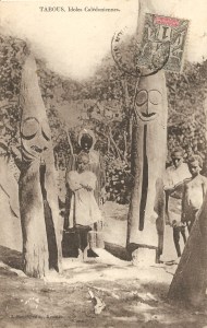 « Tabous, Idoles Calédoniennes [Vanuatu]. J. Raché, édit., Nouméa. ». 13,8 x 8,8 cm. Orchestre de tambours à fente dressés verticalement, style d’Ambrym. Principaux monuments de la place de cérémonie, ces grands tambours appartiennent à des personnages importants et de grandes fêtes sont organisées à l’occasion de leur érection. Utilisés dans la vie quotidienne pour envoyer des messages et lors des cérémonies où ils rythmaient les chants et les danses, leurs sons sont codés en fonction du grade de la personne que l’on appelle ou correspondent à des événements particuliers. La taille des tambours et le nombre de leurs visages sont en relation avec la position dans la hiérarchie des grades de leur commanditaire.