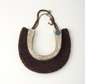 Pectoral tahi põniu, taki poõniu, îles Marquises, première moitié du XIXe siècle. Bois, graines (põniu, Abrus precatorius), écorce interne battue (tapa) (hau, Hibiscus tiliaceus). Dim. : 24,5 × 10 × 3 cm (env.) Ex-coll. Alphonse Moillet, don à la Ville de Lille en 1851. © Musée d’Histoire Naturelle, Lille, Inv. 990.2.2692. Photo : P. Bernard.