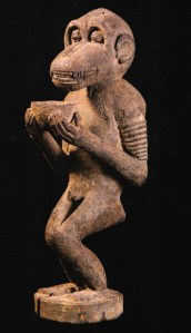 Porteur de coupe aux jambes croisées, Baule, Côte d’Ivoire. Ses bracelets indiquent son usage par le culte du mbra. Bois et matières sacrificielles. H. : 62 cm. © Ex-coll. Henri Kamer, coll. privée, Bruxelles.